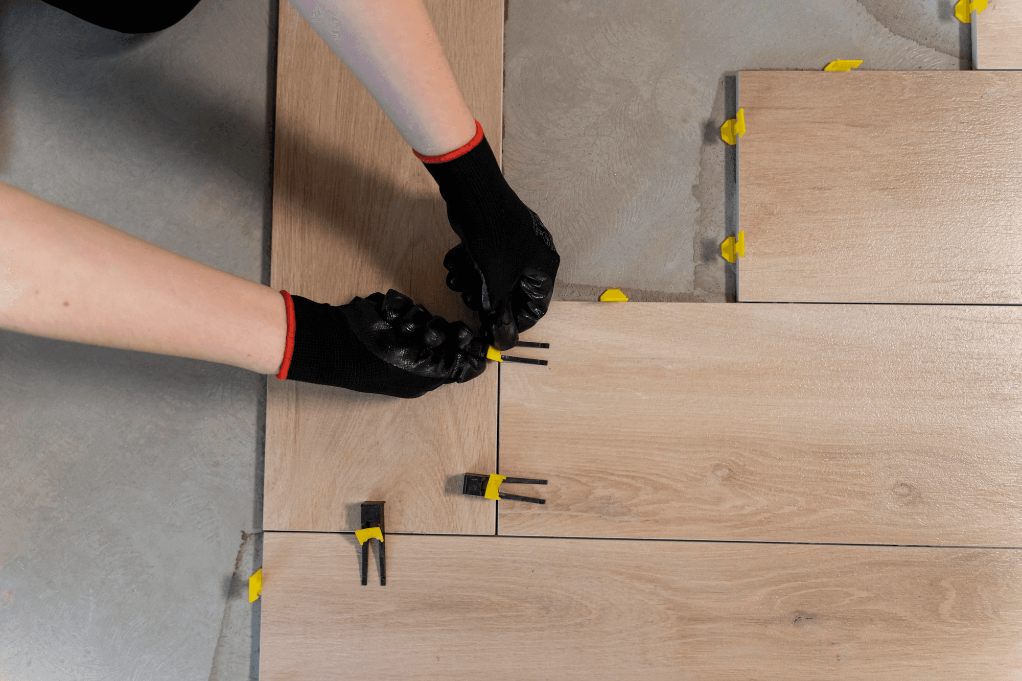 Professional installing wooden flooring with drill